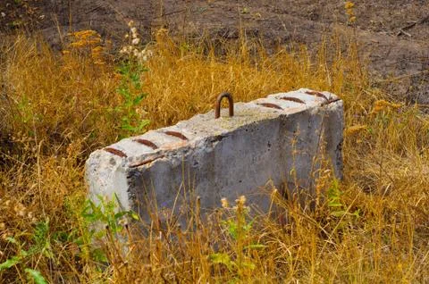 Old building block left in yellow dry grass Stock Photos