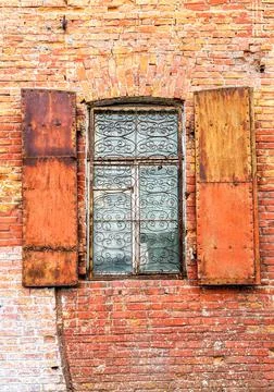 Old building brick wall with an window with hinged shutters Stock Photos