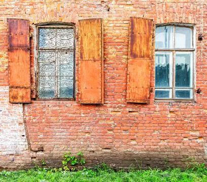 Old building brick wall with an window with hinged shutters Stock Photos