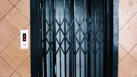 Old building elevator coming up - vintage gate lift arriving at floor Stock Footage 313605375