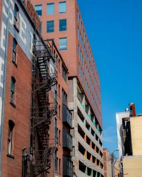 Old building with fire escape on side of building in downtown Photos