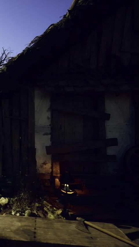 Old building at night with lantern light and rustic tools nearby Stock Footage 339957866