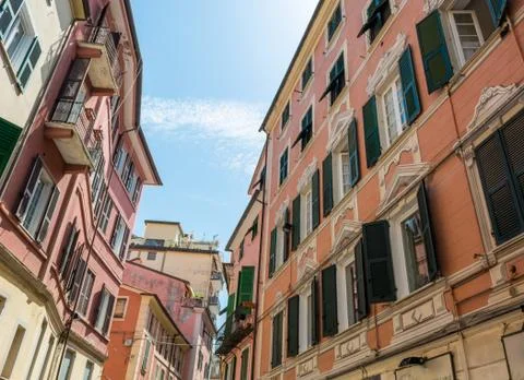 Old building with red facade and green windows. Stock Photos