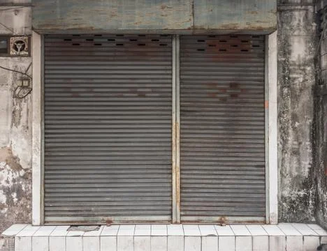 Old building with a rusty roller shutter door Stock Photos