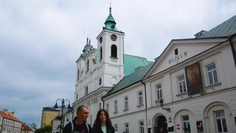An old building with towers and a clock in a European city. People are walking Stock Footage 247912499