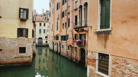 Old buildings and a narrow canal for boats and gondolas in Venice. A typical Stock Footage