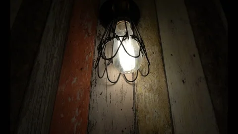 Old bulb shines in the dark on the background color boards Stock Footage 101132500