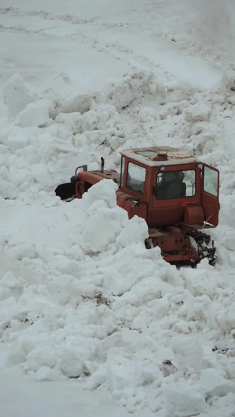 An old bulldozer shovels a big pile of snow Stock Footage 340265588
