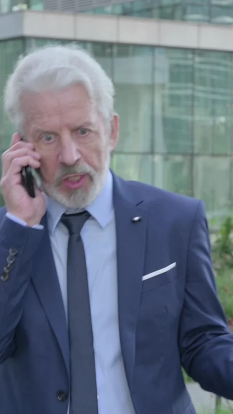 Old Businessman getting Angry on Call while Walking on the Street, Vertical Stock Footage 339671084