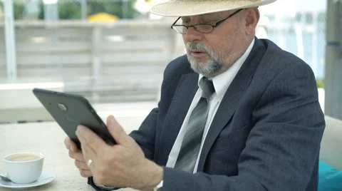 Old businessman talking via internet with tablet. 4K Vídeo Stock 66779468