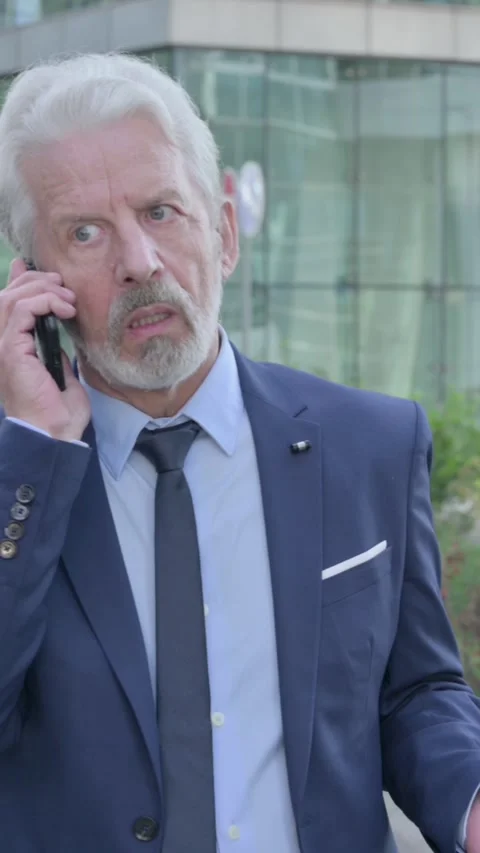 Old Businessman Talking on Phone while Walking on the Street, Vertical Video Vídeo Stock 339670938