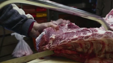 Old butcher cutting pig meat with saw in slow motion Stock Footage 44325080