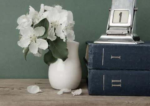 Old calendar and bird cherry branch in a jug on the wooden table Photos