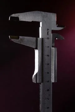 Old caliper in backlight with red light on the background. Stock Photos