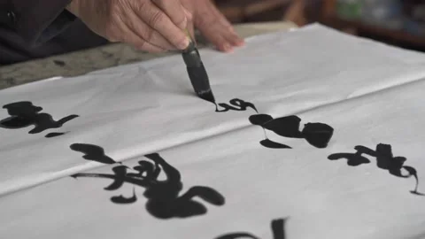 An old calligrapher is creating and writing Chinese calligraphy works. Stockbeeldmateriaal 191050237