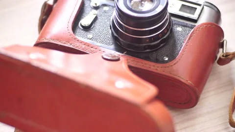 Old camera in a brown leather case covered in dust Stock Footage 139688081