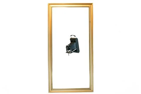 Old camera flying in a picture frame Stock Photos