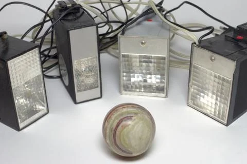Old camera pulse flashes, surrounding the ball of marble onyx. Closeup Stock Photos