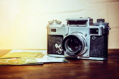 Old camera is on the table on a stack of photos Stock Photos