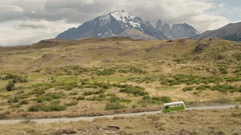 Old campervan driving down a road in Patagonia Stock Footage 258424157