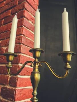 Old candlestick against the backdrop of a brick wall Stock Photos