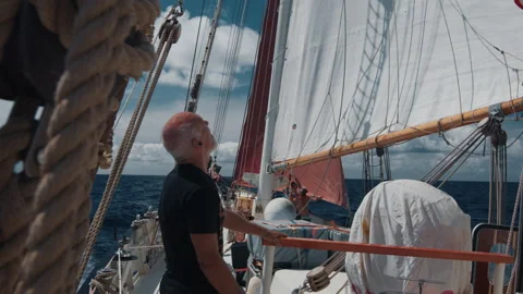 Old captain controls the crew working with the sails on the big expeditional Stock Footage 341982655