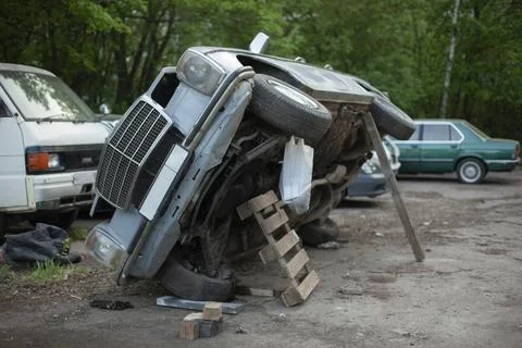 The old car is being repaired. The machine has been lifted to inspect the und Stock Photos