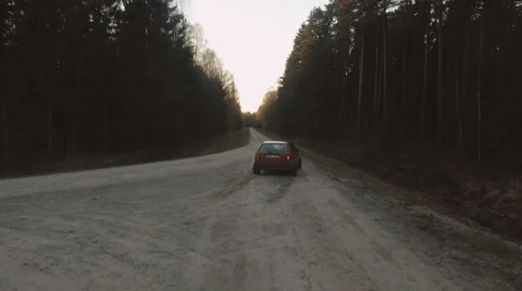 Old car drive through forest road in a sunset Stock Footage 63333271