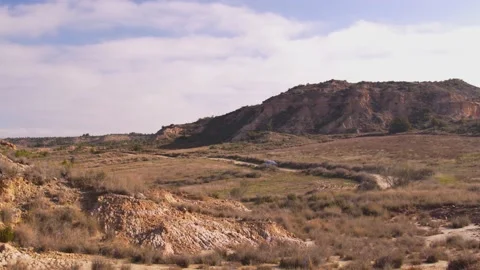 Old car driving alone on a road in a desert, in Spain Stock Footage 208784713