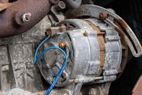 Old car engine alternator rust covered with duct tape blue wire Stock Photos