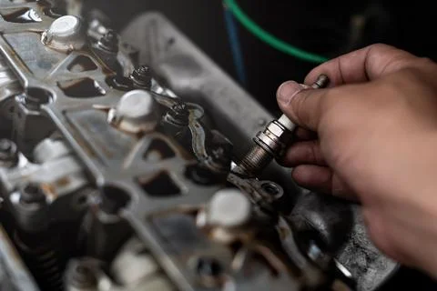 Old Car spark plug in a hand of Technician remove and change in engine room.. Stock Photos
