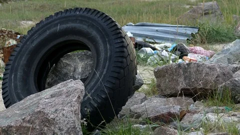 Old car tire in a clearing among the rocks. Stock Footage 84174041