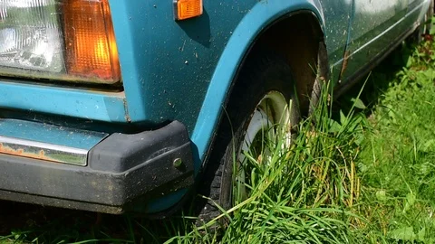 Old car with wheel in the ground, front view Stock Footage 117047629