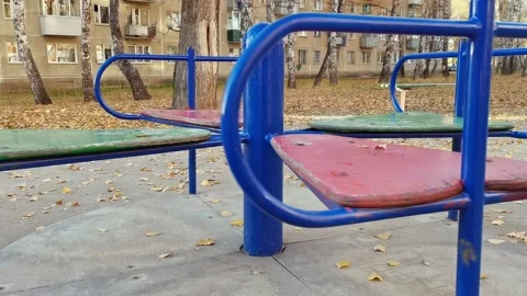 Old carousel in autumn yard at house rotates without kids. Video stock 165100618
