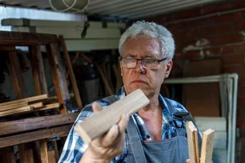 Old carpenter checking the wood planks Stock Photos