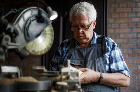 Old carpenter checking the wood planks Stock Photos