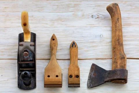 Old carpentry tools lie on a white wooden table. Stock Photos