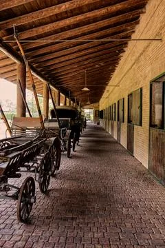 Old carriages in front of a stable. Stock Photos