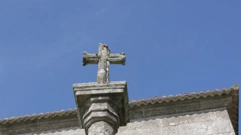 Old carved stone cross on a column and a building Видео 150954512