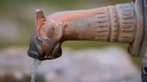 An old cast-iron hand pump column with flowing water in close-up. Stock Footage 221552020
