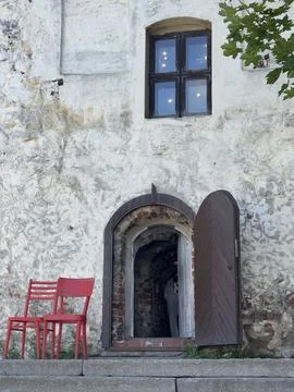 An old castle building with two red chairs for ambiance Stock Photos