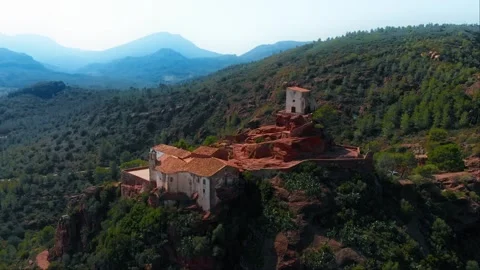 Old castle or monastery nestled on a hilltop surrounded by majestic mountains Stock Footage 268882769