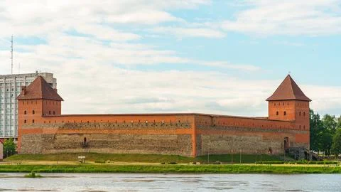 The old castle is a red brick fortress by the water. Historical architecture. Stock Photos