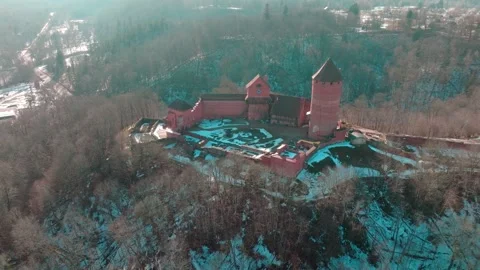 Old castle sits among trees near a winding river with snow on the ground and Stock Footage 333022616