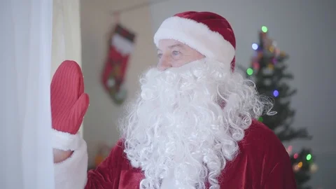 Old Caucasian man with false beard in costume of Santa Claus looking out the Stock Footage 120913742