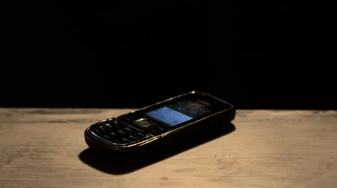 Old Cell phone ringing on wooden deck Stock Footage