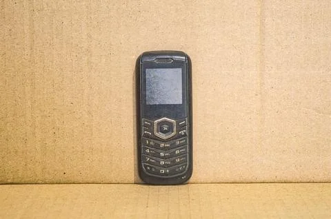 Old cellphone with a plain brown background Stock Photos
