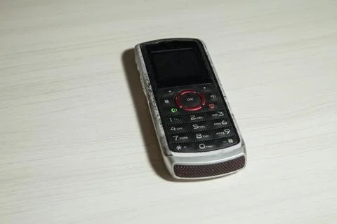 Old cellular device placed on the table top in the home office, showing the s Stock Photos