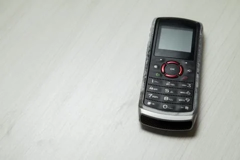 Old cellular device placed on the table top in the home office, showing the s Stock Photos