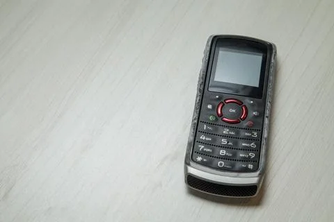 Old cellular device placed on the table top in the home office, showing the s Stock Photos